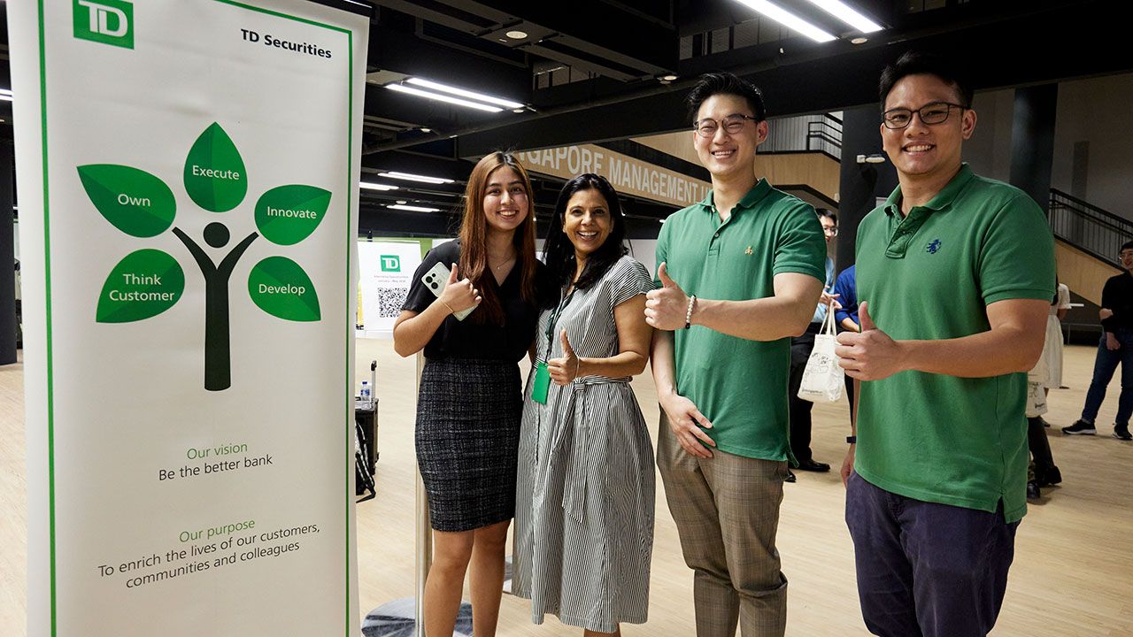 Students standing next to Career Fair standee